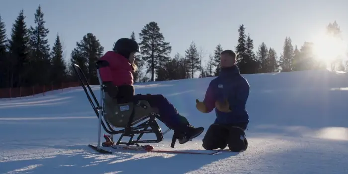 Jente i sit-ski får veiledning av instruktør. Foto: Teddy TV