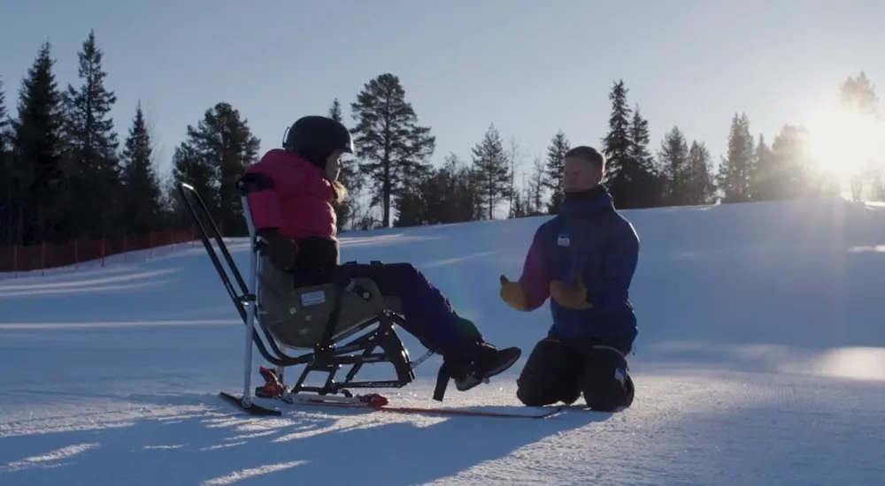 Jente i sit-ski får veiledning av instruktør. Foto: Teddy TV