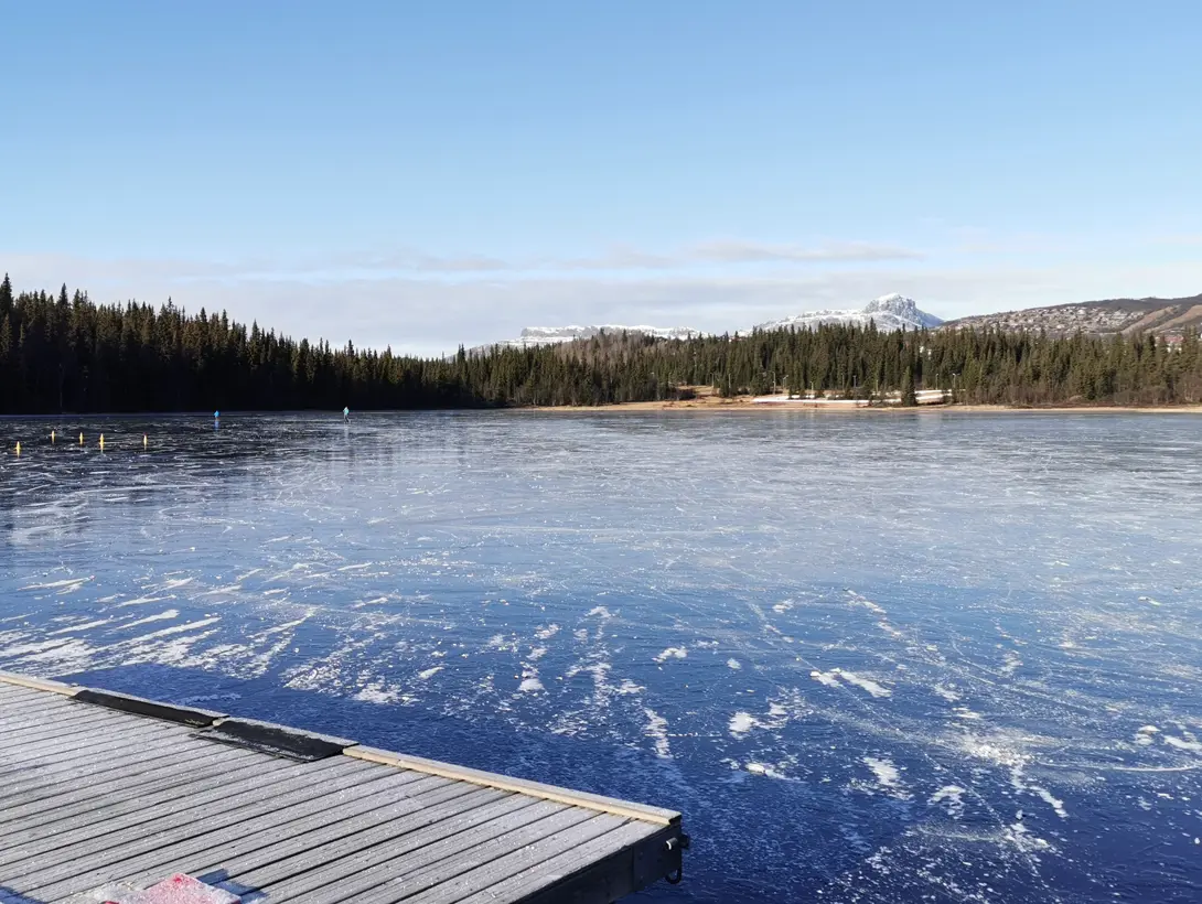 Et islagt Bamselitjern med fjellet Bitihorn i bakgrunnen