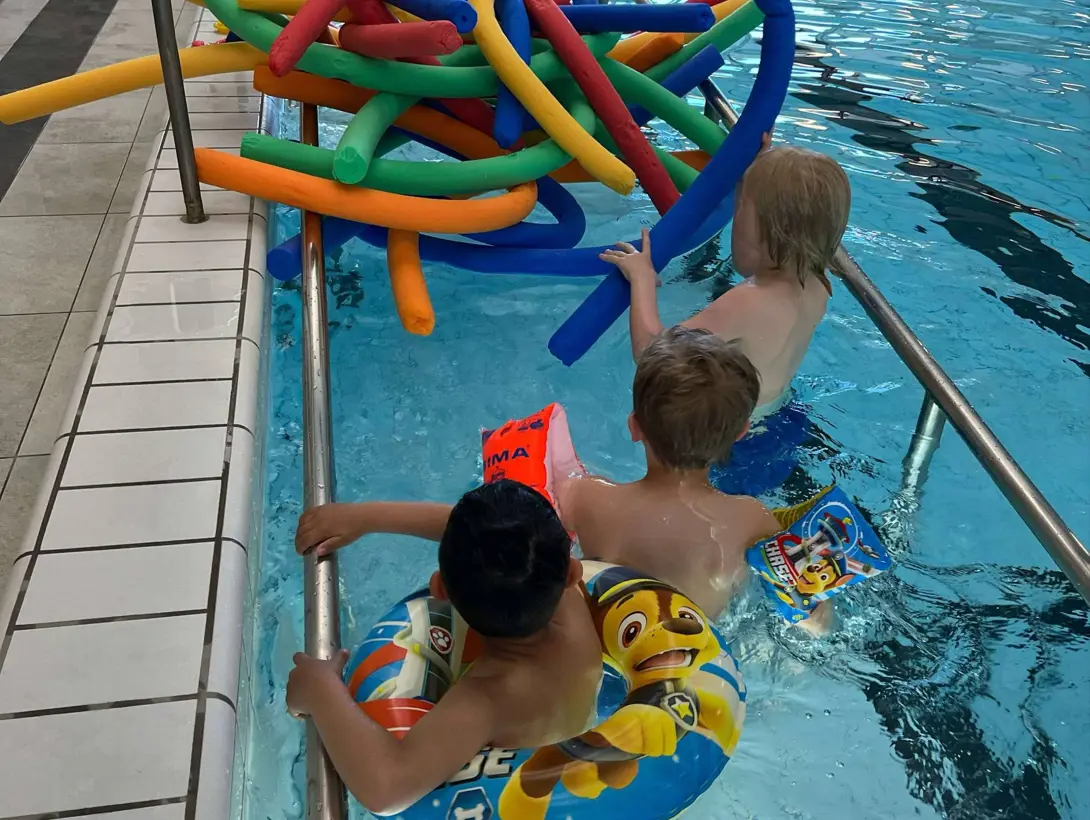 Lek med flytepølser i bassenget