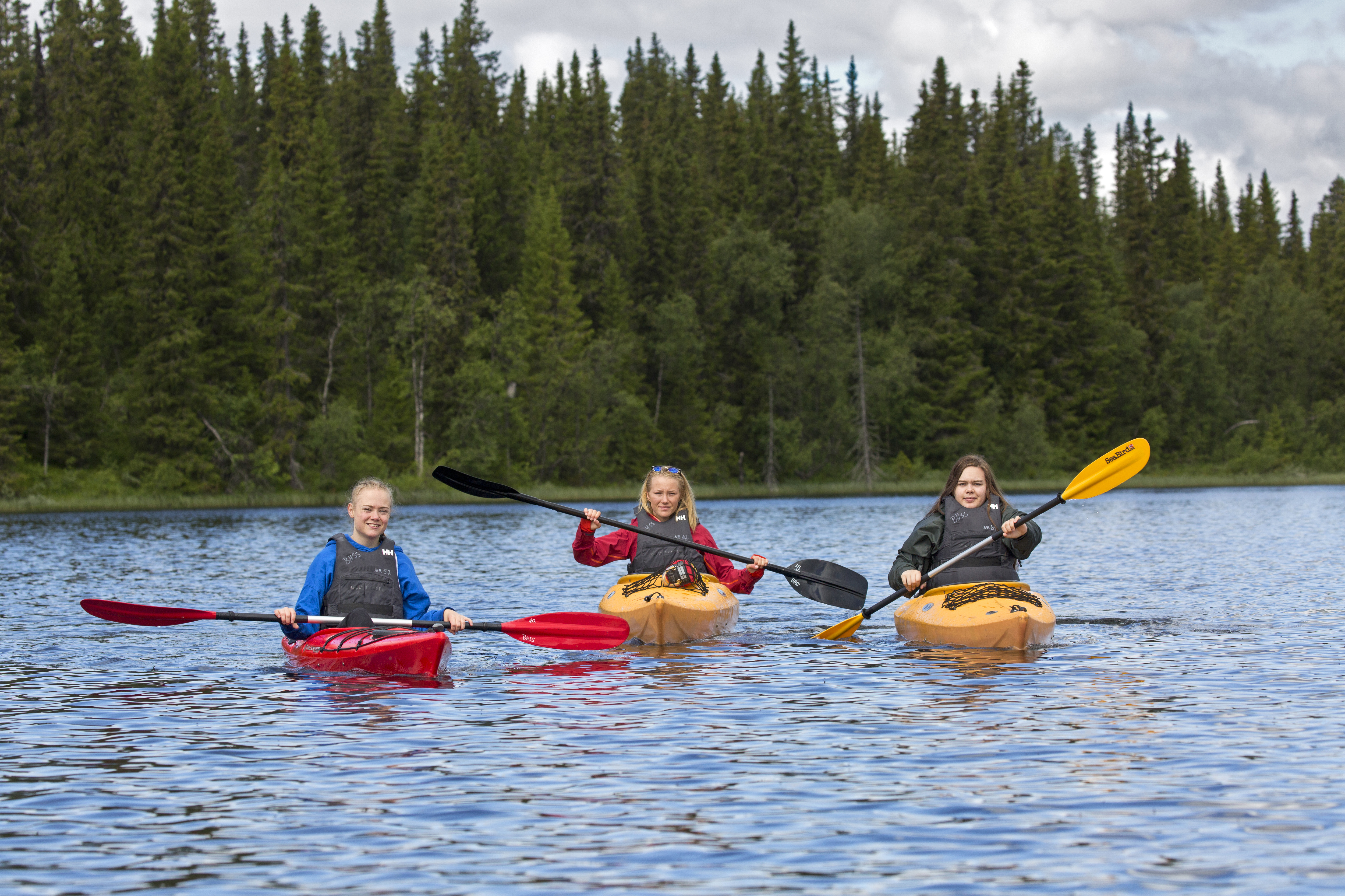 Tre jenter padler kajakk. Foto: Thor Østbye