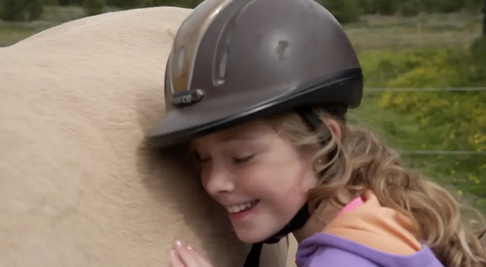 Jente koser med hesten